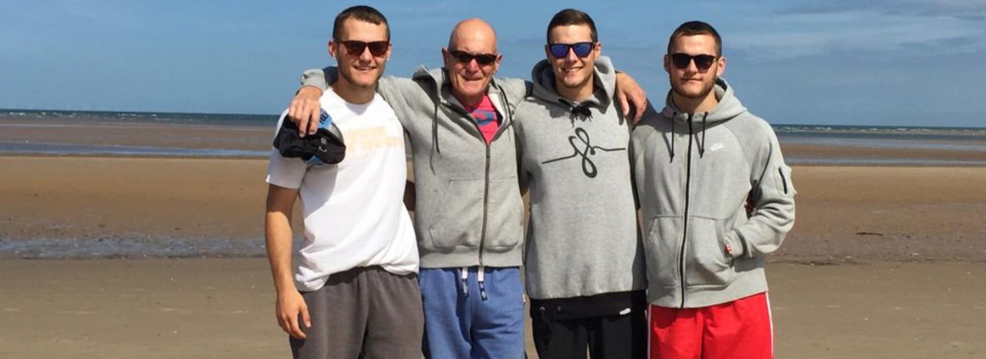 Andrew brothers and dad posing by the beach